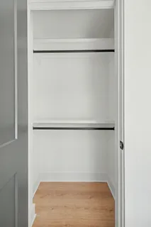 a view of a closet with wooden floor