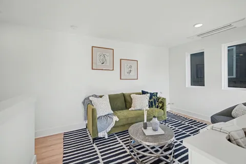 a living room with furniture and wooden floor