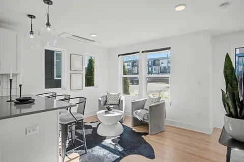 a living room with furniture a flat screen tv and a window