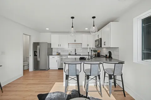 a kitchen with stainless steel appliances kitchen island granite countertop a refrigerator and microwave