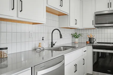 a kitchen with stainless steel appliances granite countertop a sink a stove and cabinets