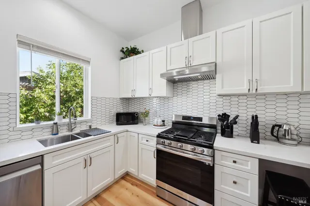 a kitchen with cabinets appliances a sink and a window