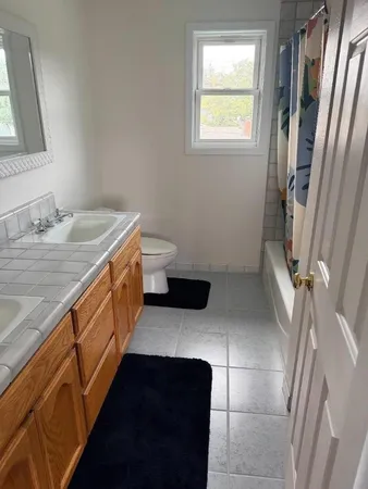 a bathroom with a sink a toilet and a window