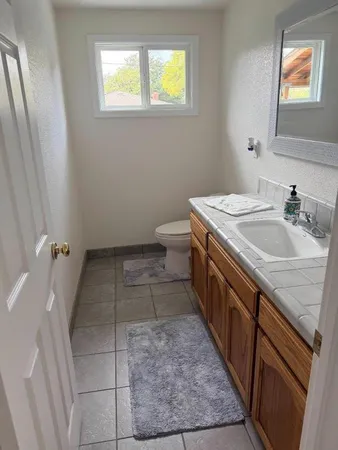 a bathroom with a sink a toilet and window
