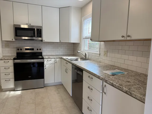 a kitchen with stainless steel appliances granite countertop a sink stove and microwave
