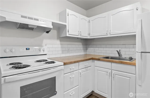 a kitchen with white cabinets and white appliances