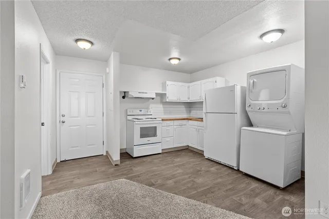 a kitchen with white cabinets and white appliances