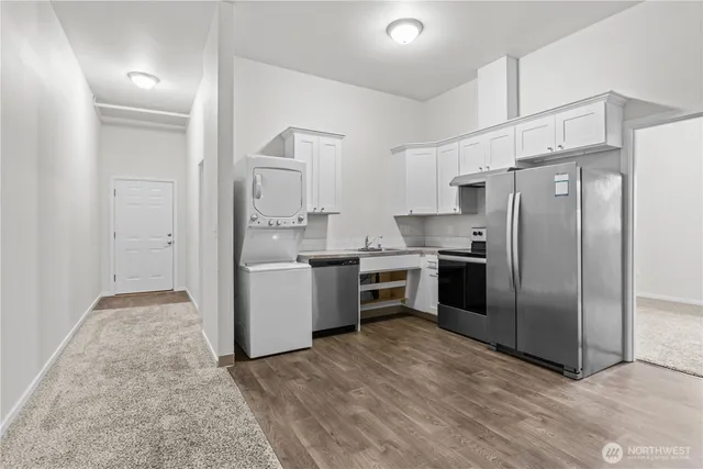 a kitchen with a refrigerator sink and cabinets