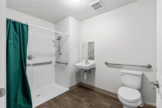 a white toilet sitting next to a shower