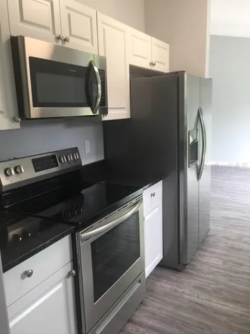 a kitchen with stainless steel appliances granite countertop a refrigerator and a microwave