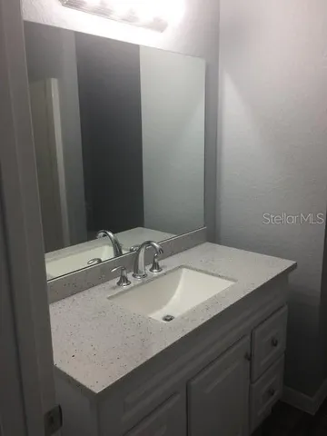 a bathroom with a sink vanity and a mirror