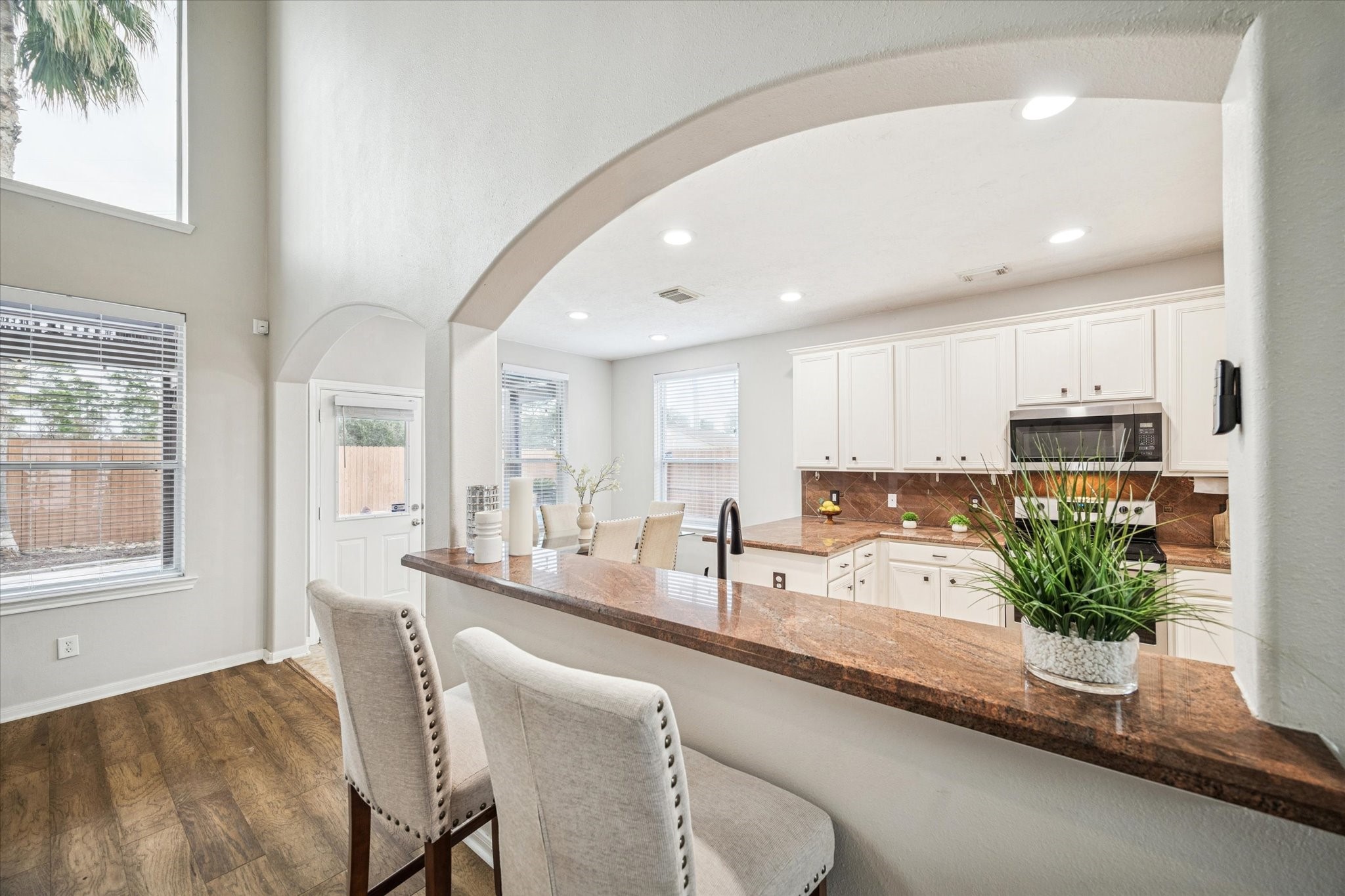 7243 Emerald Run Lane Spring, TX 77379 - Photo 14 of 35 a room with stainless steel appliances kitchen island granite countertop a stove a sink and a dining table with wooden floor