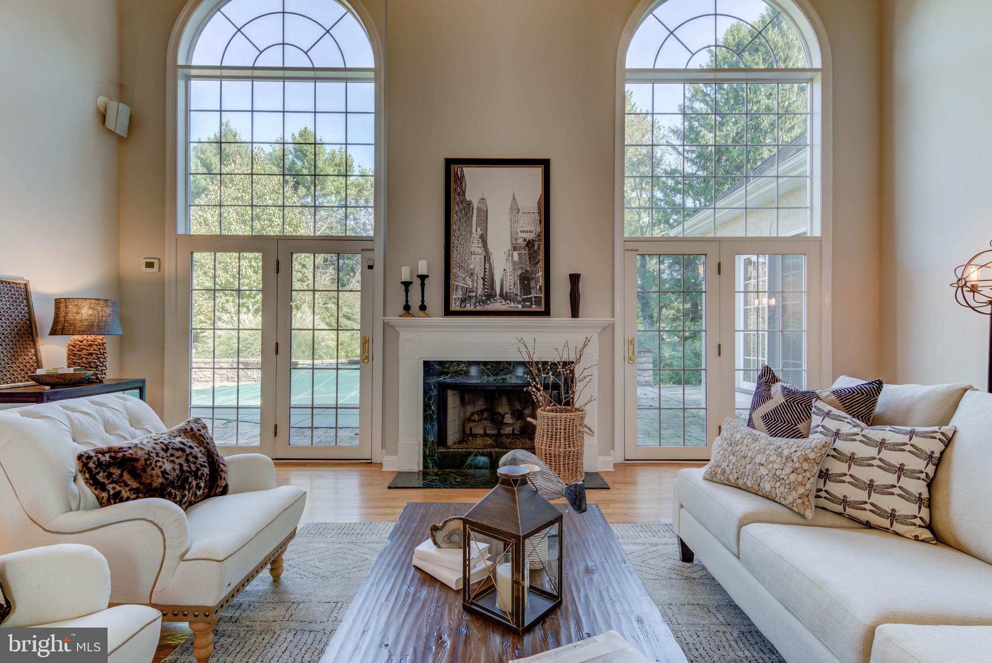 a living room with furniture large window and fireplace