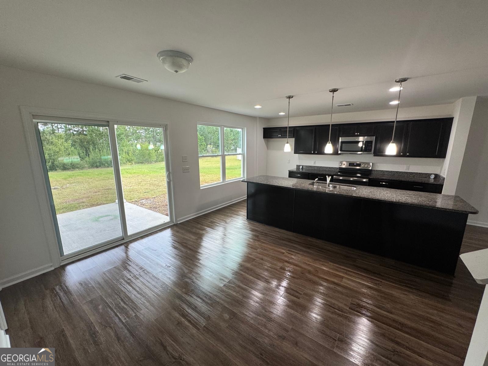 435 Wilkins Road Midway, GA 31320 - Photo 4 of 22 a kitchen with stainless steel appliances granite countertop a sink a stove and wooden floors