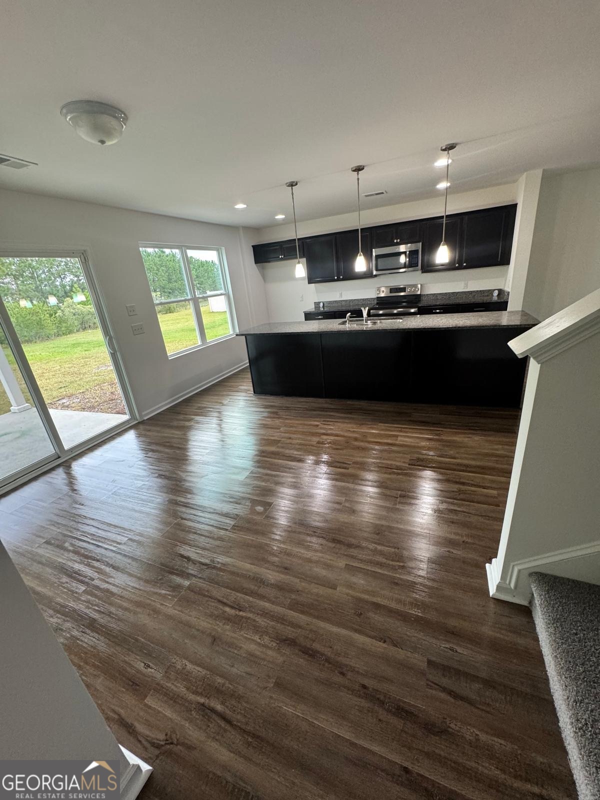 435 Wilkins Road Midway, GA 31320 - Photo 6 of 22 a kitchen with stainless steel appliances kitchen island granite countertop a stove window and wooden floor