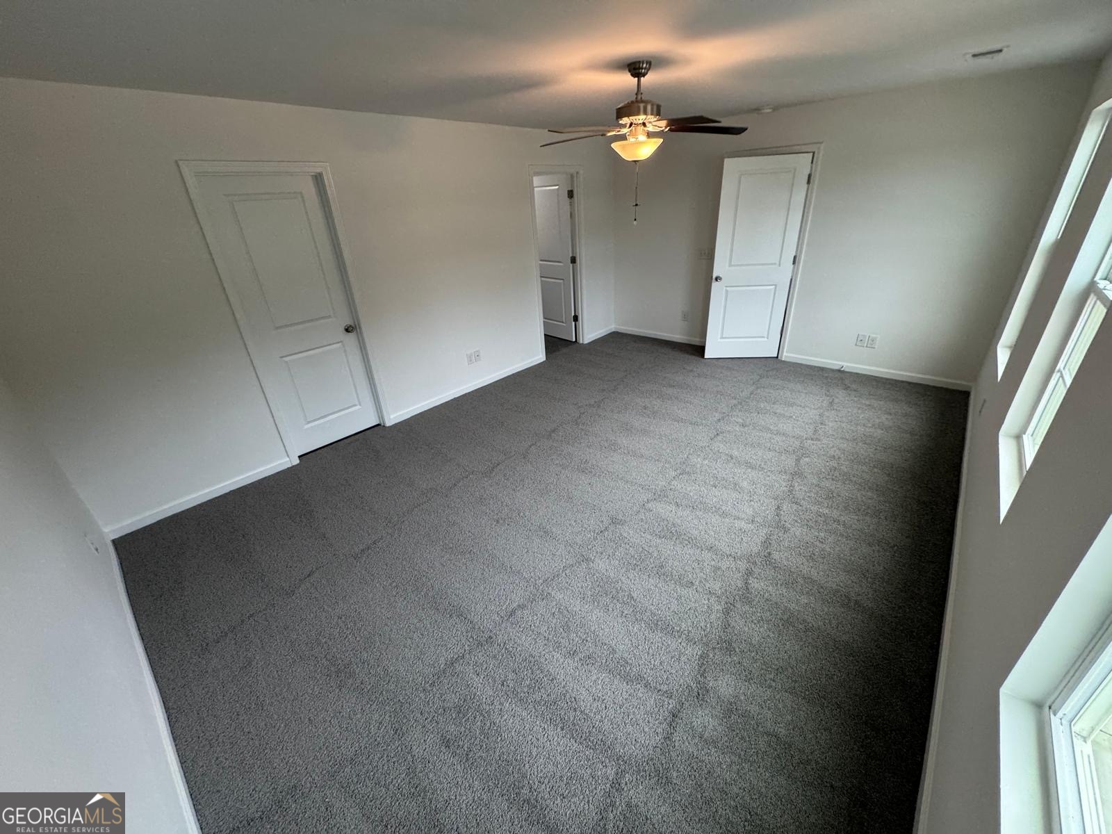 435 Wilkins Road Midway, GA 31320 - Photo 10 of 22 an empty room with chandelier fan and windows