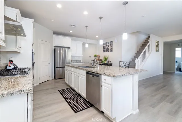 a kitchen with granite countertop white cabinets and a sink