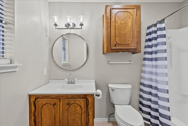 a bathroom with a toilet a sink and a mirror