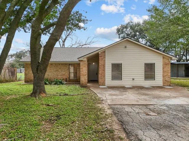a front view of a house with a garden and trees