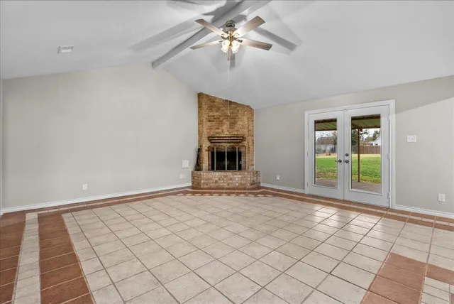 a view of an empty room with window chandelier fan