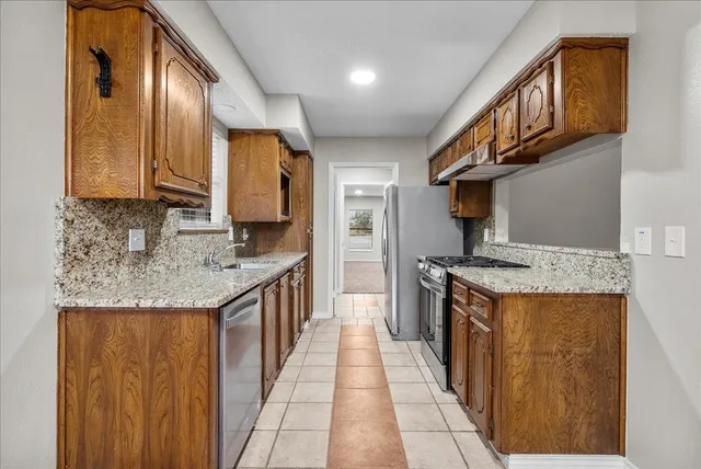 a kitchen with stainless steel appliances granite countertop a sink and a stove