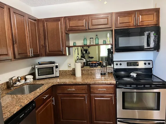 a kitchen with stainless steel appliances granite countertop a stove microwave and sink