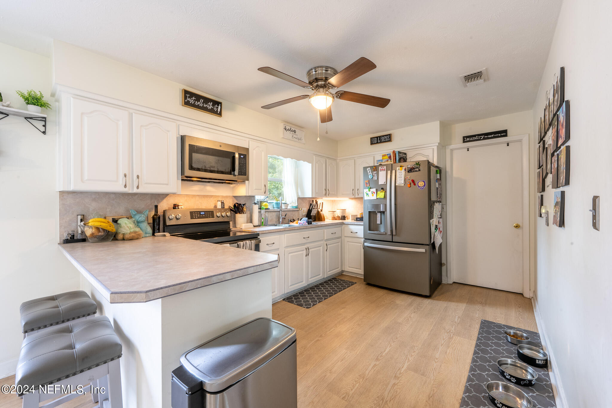 301 Penman Road Neptune Beach, FL 32266 - Photo 10 of 31 a kitchen with a refrigerator a stove top oven a sink dishwasher and white cabinets with wooden floor