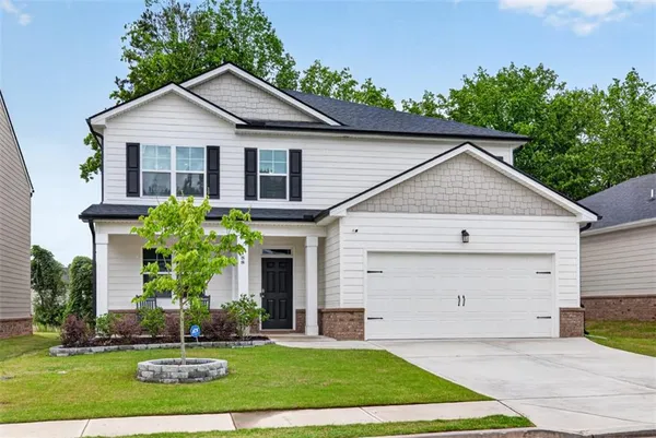 a front view of a house with a yard and garage