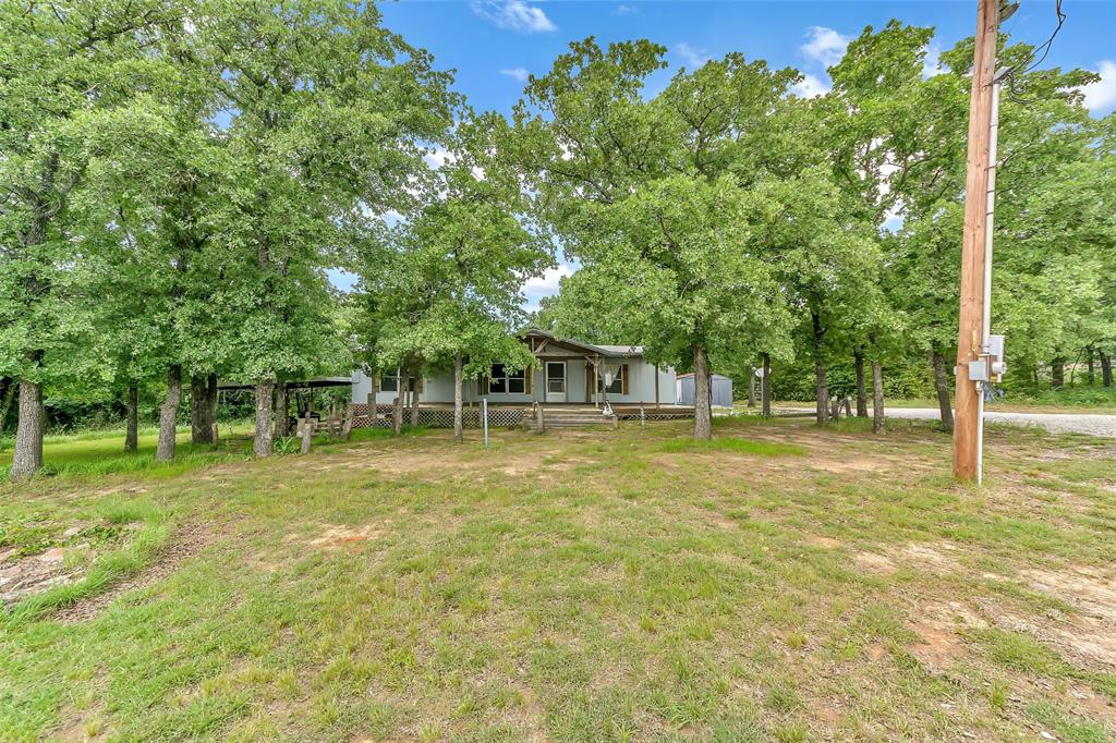 Large front yard with scattered trees for shade.