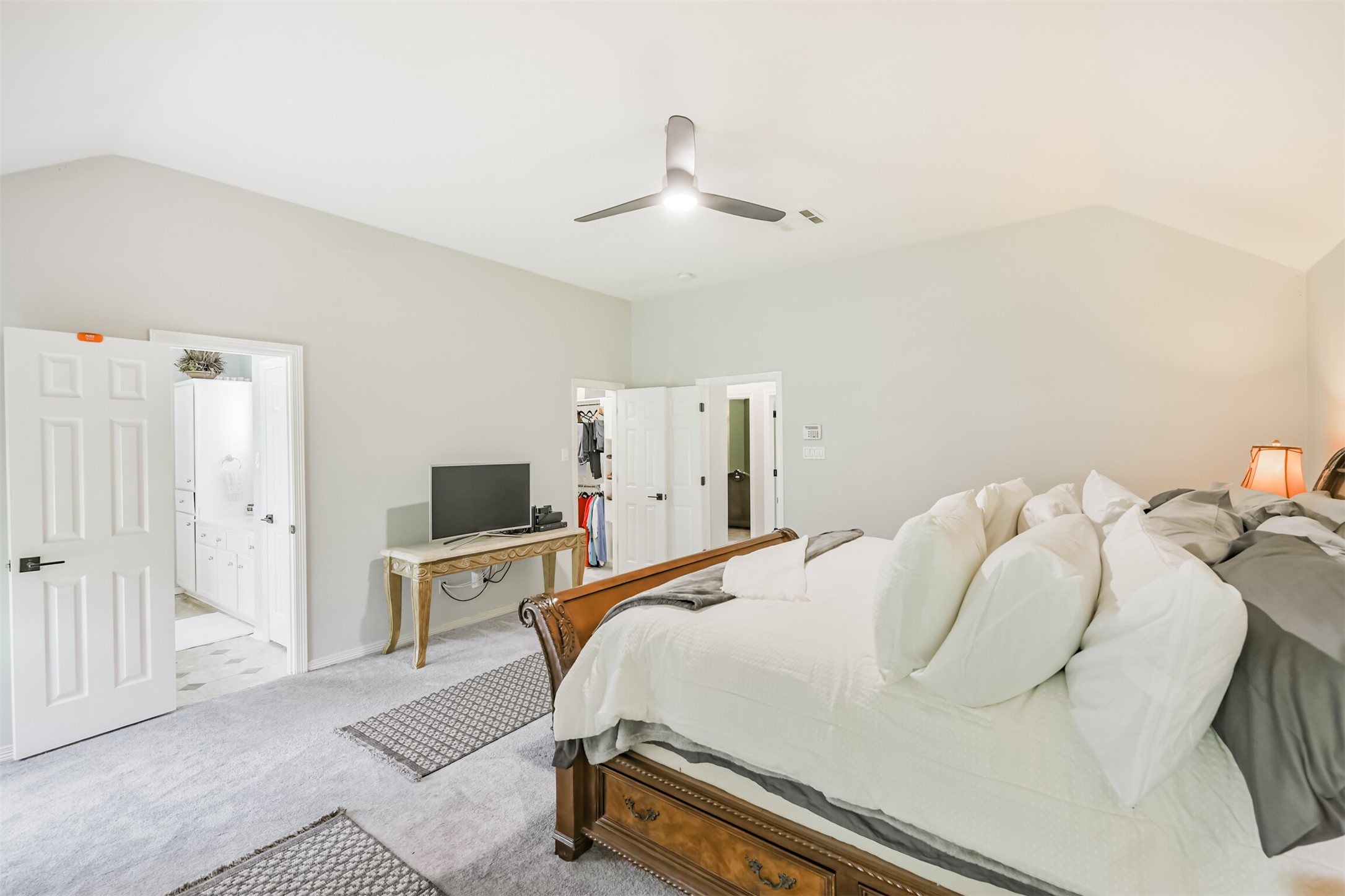 6002 Ranch Park Road Magnolia, TX 77354 - Photo 17 of 49 A view into a Primary en-suite bathroom with dual sinks. A walk-in closet is also visible, offering ample storage.