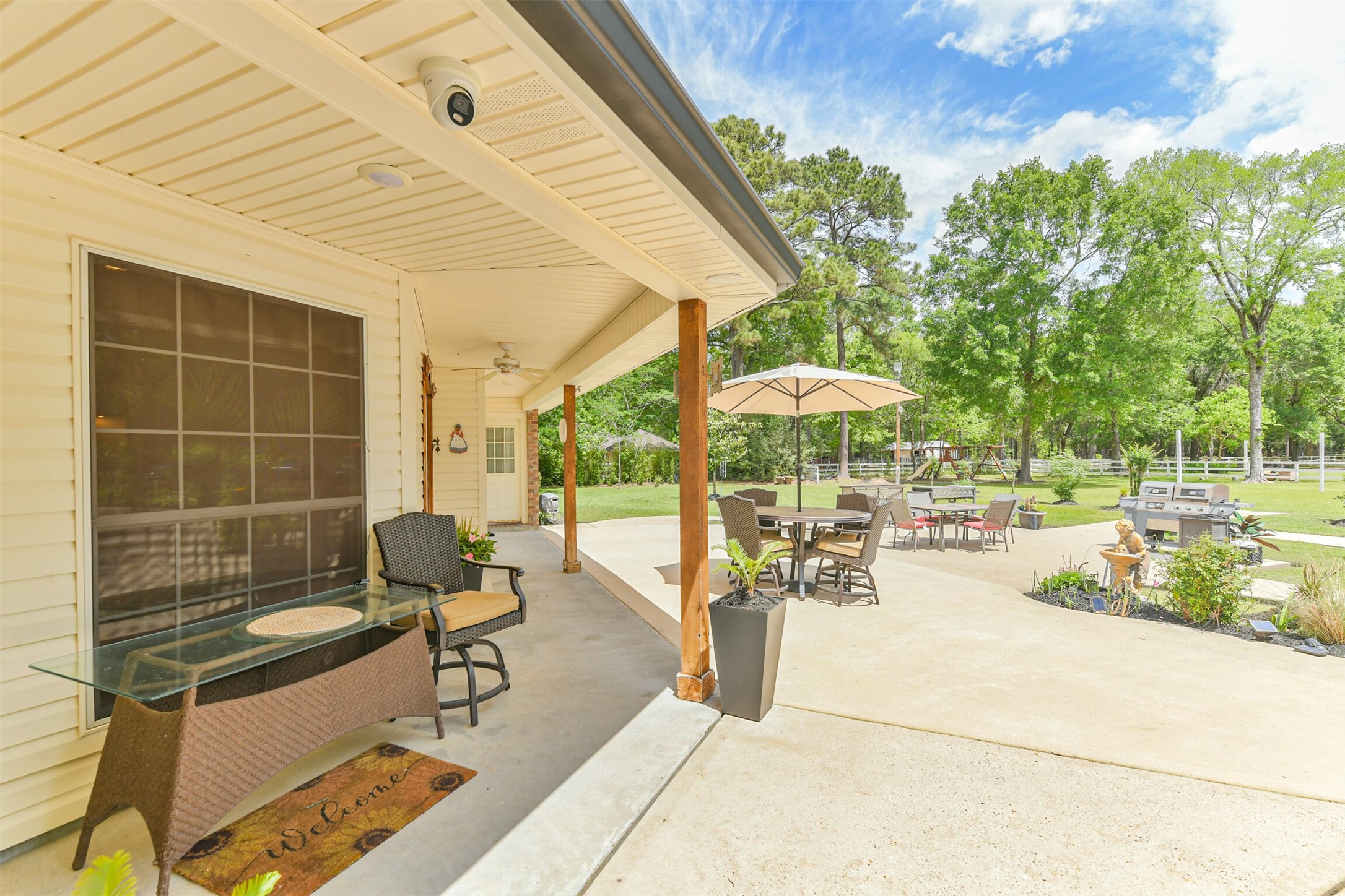 6002 Ranch Park Road Magnolia, TX 77354 - Photo 27 of 49 This photo showcases a spacious backyard patio area with a covered porch and lush greenery. Ideal for entertaining or relaxing outdoors.