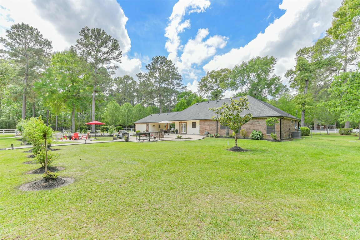6002 Ranch Park Road Magnolia, TX 77354 - Photo 42 of 49 This property features 2.9 acre with lush green grass and mature trees, offering a serene, private retreat. The patio area is perfect for outdoor gatherings.