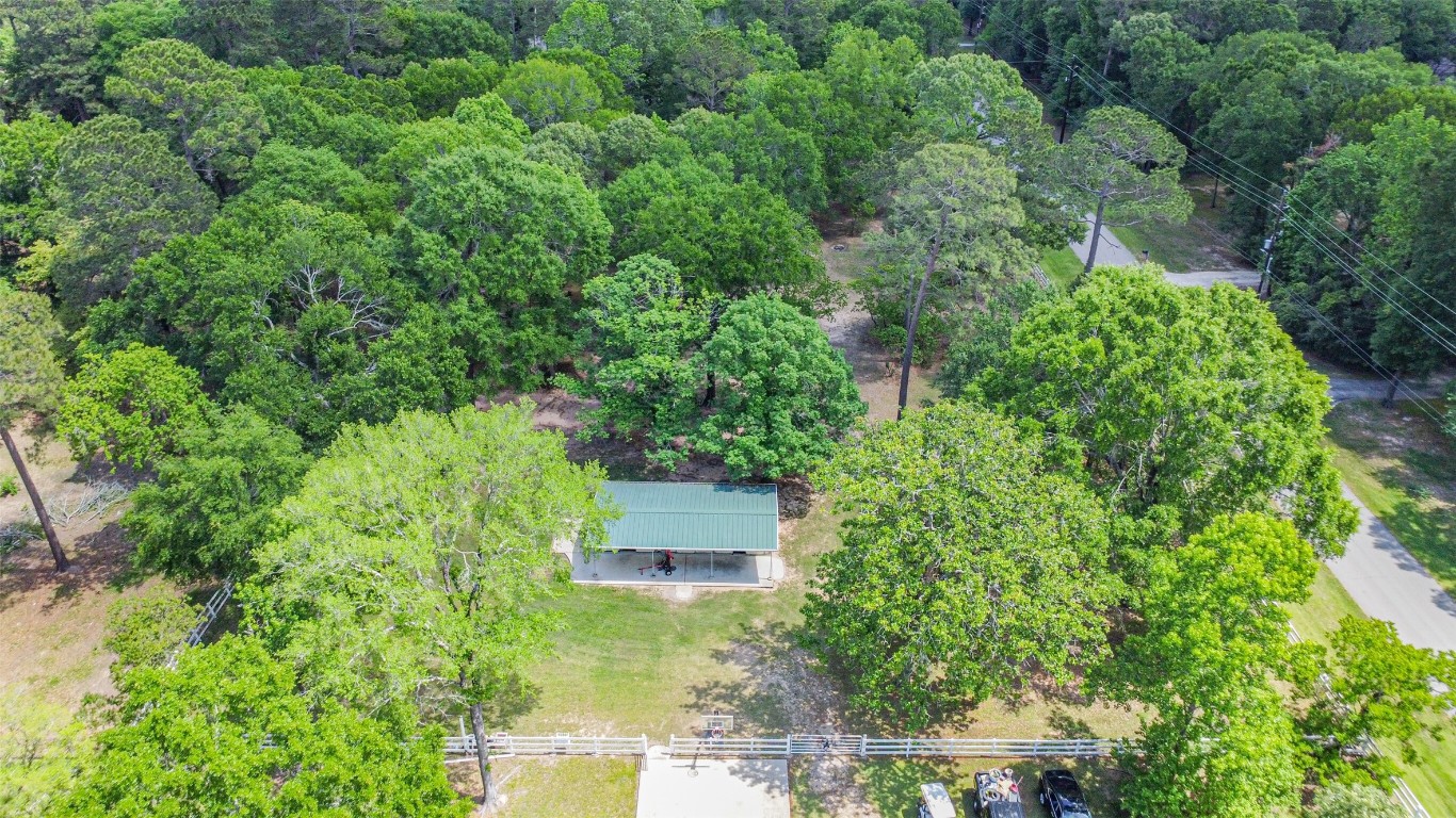 6002 Ranch Park Road Magnolia, TX 77354 - Photo 44 of 49 This aerial photo showcases a serene property surrounded by lush, green trees, offering privacy and a natural setting. Ideal for those seeking a peaceful, wooded environment.