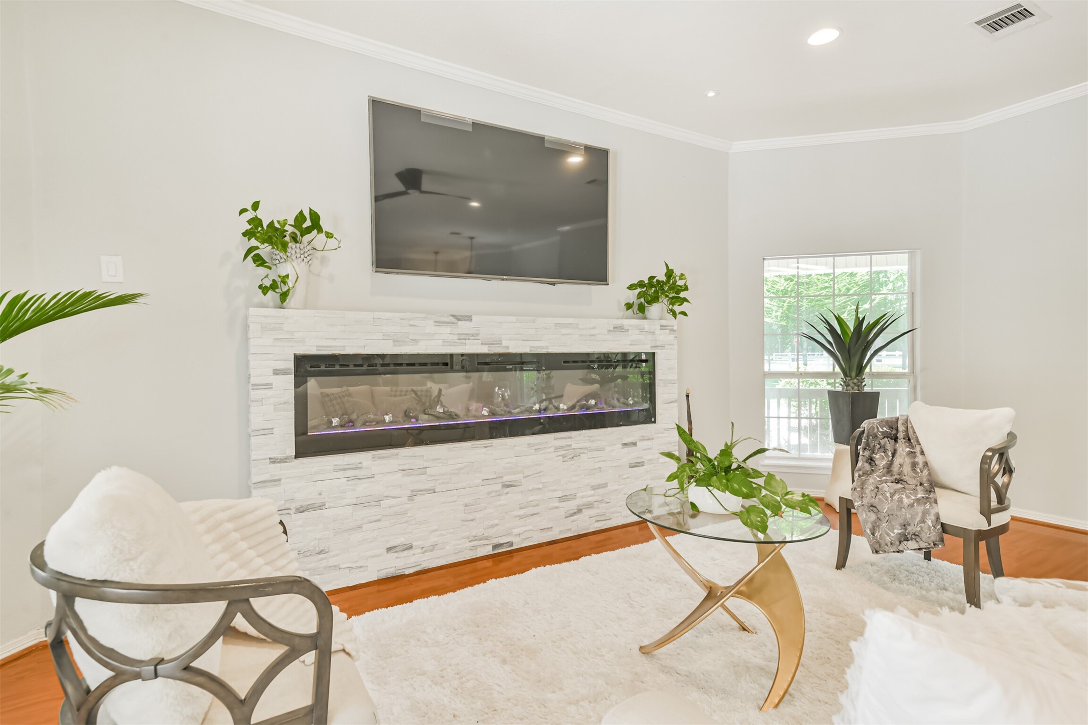 6002 Ranch Park Road Magnolia, TX 77354 - Photo 6 of 49 The living room features a modern electric fireplace with a sleek stone surround, a mounted TV, large window for natural light.