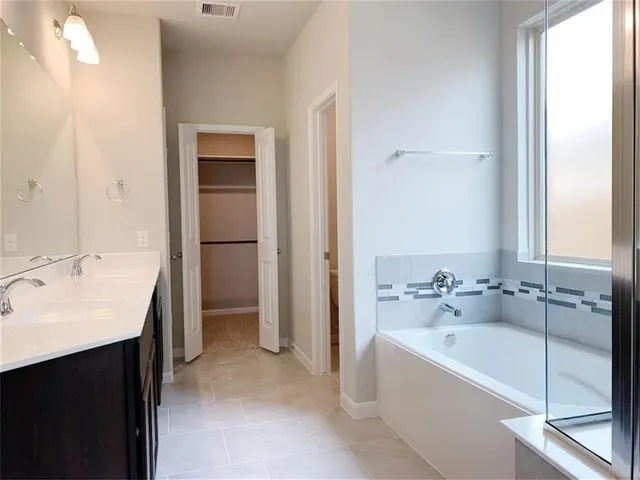 a bathroom with a tub sink and mirror