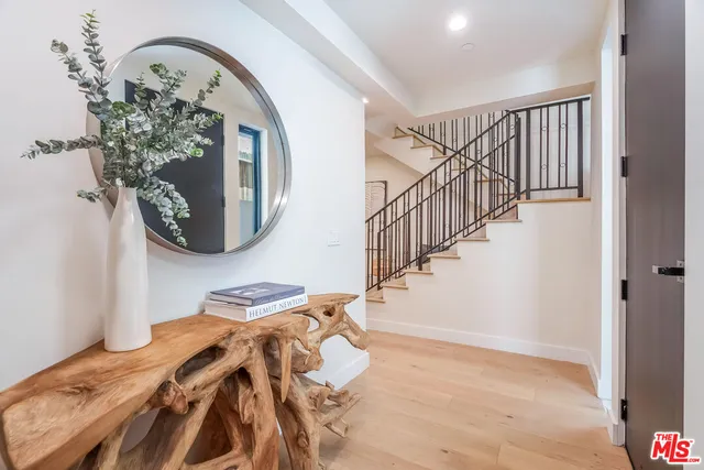 a view of a bedroom with wooden floor and stairs