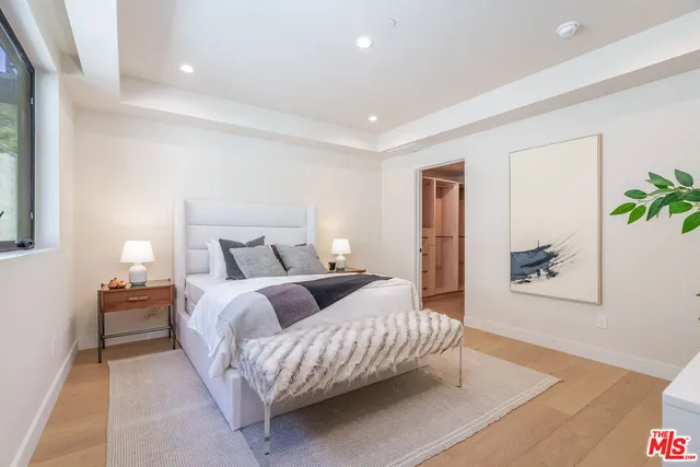 a spacious bedroom with a bed and a lamp