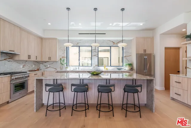 a kitchen with a dining table chairs stove and white cabinets