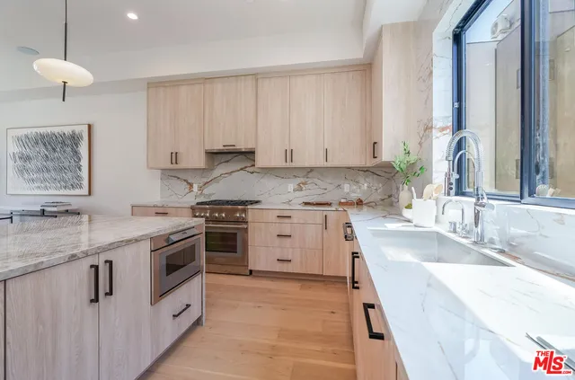 a kitchen with granite countertop a sink stove and cabinets