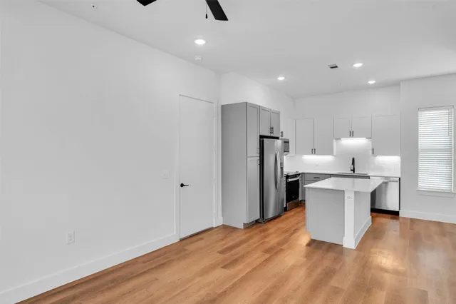 a kitchen with a refrigerator and a stove top oven