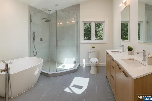 a bathroom with a double vanity sink toilet and shower