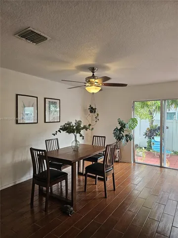 a view of a dining room with furniture a chandelier and wooden floor