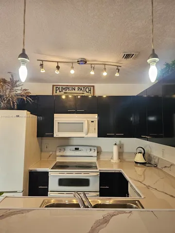 a view of a kitchen with a sink and refrigerator