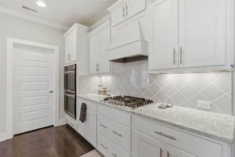 a large kitchen with kitchen island a dining table chairs and a wooden floor