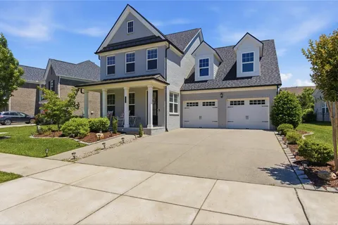 a front view of a house with yard and green space