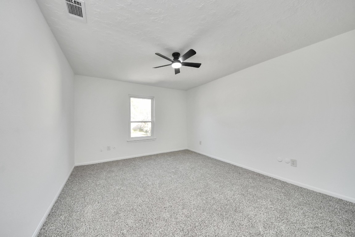 18803 Oakway Drive Spring, TX 77388 - Photo 35 of 47 an empty room with windows and chandelier fan
