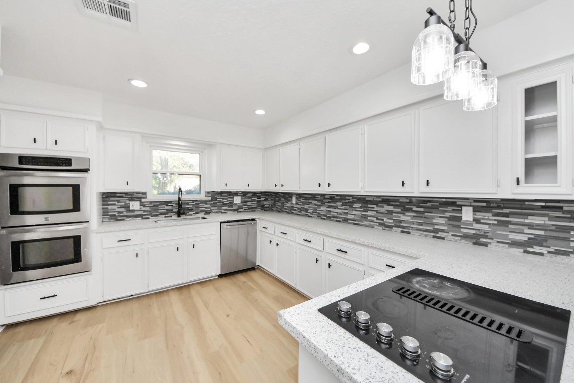 18803 Oakway Drive Spring, TX 77388 - Photo 9 of 47 a kitchen with granite countertop a stove and white cabinets