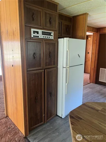 a view of kitchen with refrigerator and wooden floor