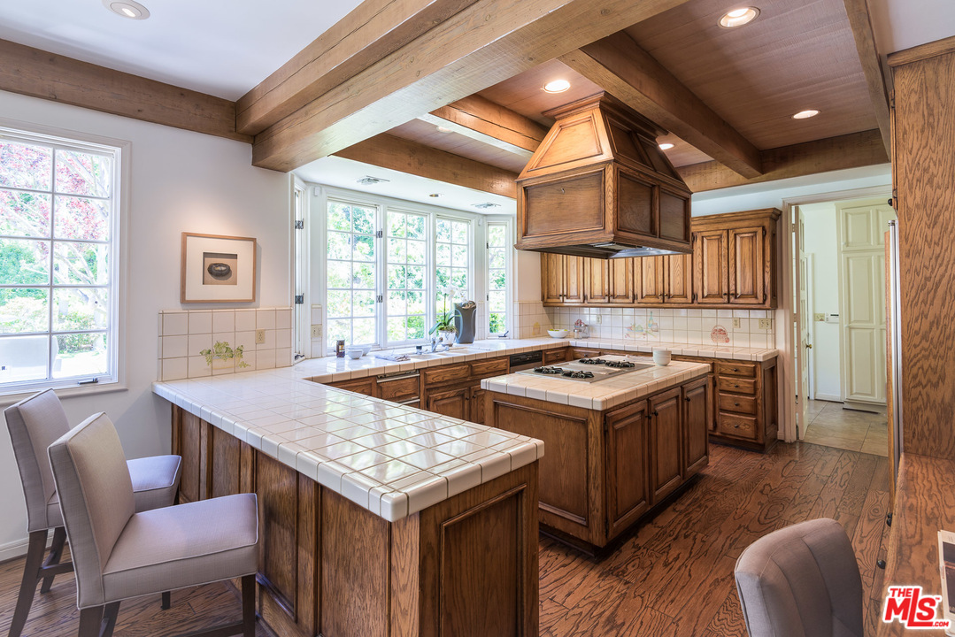 1420 Moraga Drive Los Angeles, CA 90049 - Photo 12 of 38 a kitchen with a stove a sink dishwasher and a refrigerator