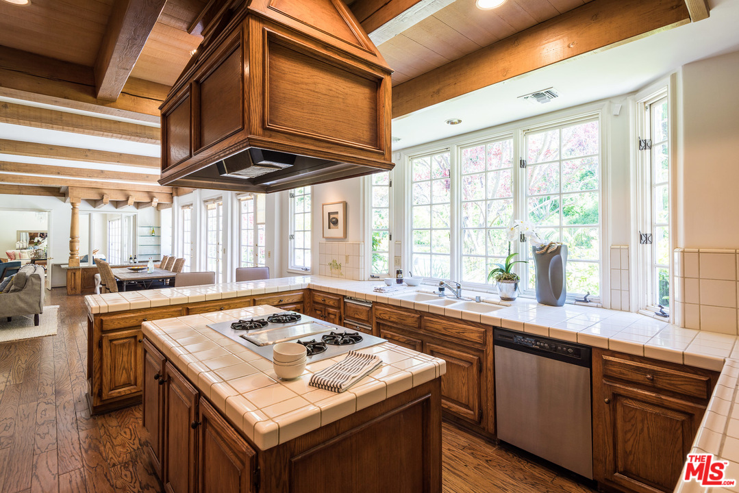 1420 Moraga Drive Los Angeles, CA 90049 - Photo 13 of 38 a kitchen with a stove a sink dishwasher and cabinets with wooden floor